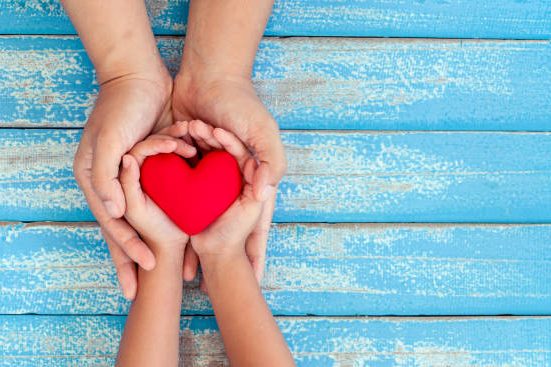 A image of a pair of hands holding a heart